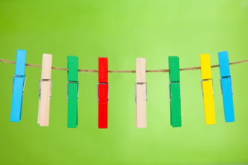 wooden clothespin hanging on rope.  colorful clothespins.