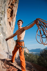 Rock climber collecting belay rope over the mountains