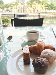 Morning cup of coffee with selection of sweet cakes.