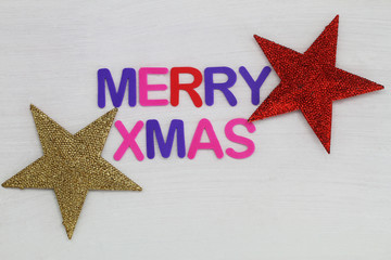 Merry Christmas written with colorful letters and red and golden stars
