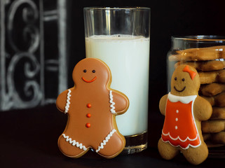 Gingerbread couple meeting near a glass of milk