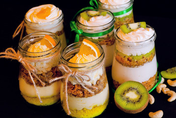 Orange and kiwi sweet desserts in glass waiting for children