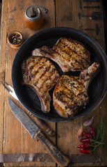 Grilled pork chop with spices in a frying pan