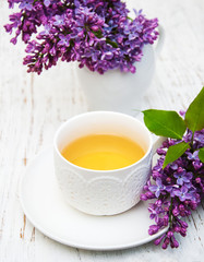 Obraz na płótnie Canvas Cup of tea and lilac flowers