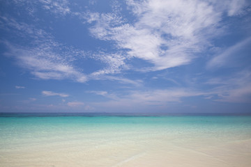 tropical beach with blue sky and calm blue sea surf