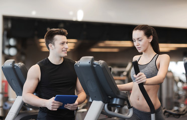 woman with trainer exercising on stepper in gym