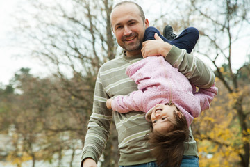 Playful father and daughter in park