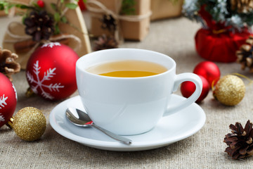 Christmas table with green tea and christmas balls.