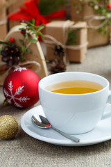 Christmas table with green tea and christmas balls.