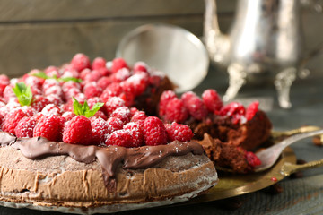 Cake with Chocolate Glaze and raspberries on tray on wooden background