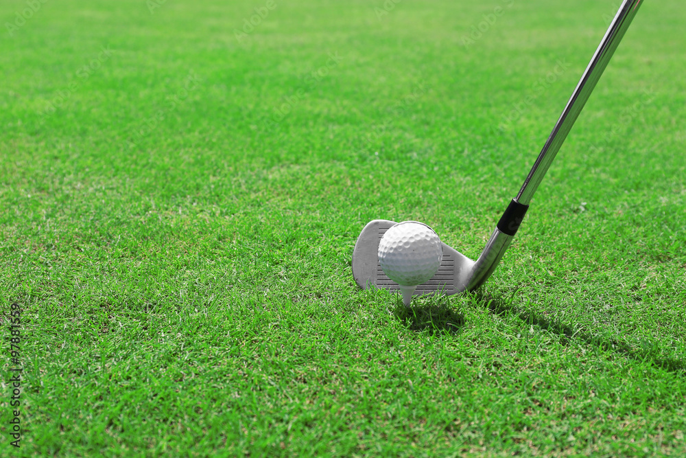 Sticker Golf club and ball on a green grass