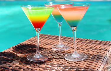 Cocktails on swimming pool background