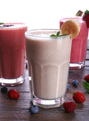 Glasses of fresh cold smoothie with fruit and berries, isolated on white