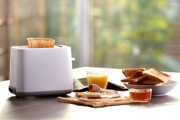 Served table for breakfast with toast and orange juice, on blurred background