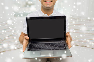 close up of happy man showing laptop at home