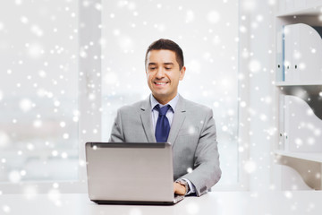 happy businessman working with laptop in office