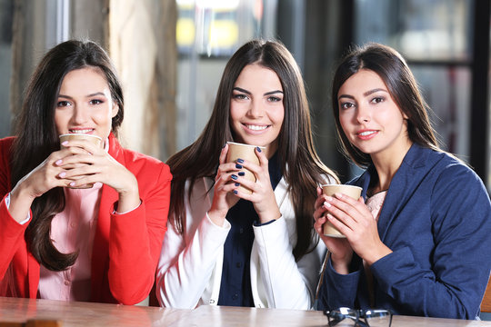 Attractive stylish girls  hold cup of coffee sitting in cafe