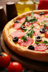 Tasty pizza with salami on decorated wooden table, close up
