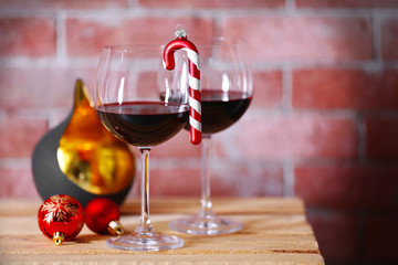 Two glasses of wine with christmas toys on wall background