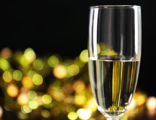 A glass of champagne with bokeh on dark background