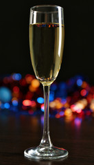 A glass of champagne with bokeh on dark background