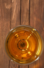 Glass of wine on wooden table. Top view