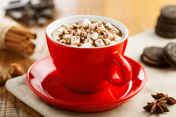Hot chocolate in red cup with marshmallow. Delicious hot chocolate with cookies.