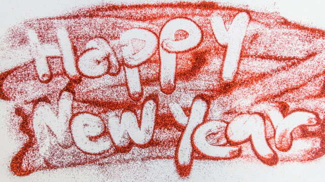 Handwriting Happy New Year on red glitter