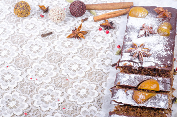 Chcolate spices cake with star anise and dried fruits, cinnamon, cloves, cardamom, handmade milk chocolate with nuts on sackcloth, canvas. Sweet frame. Free space for your text.