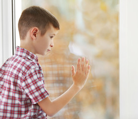 Sad boy sitting near window
