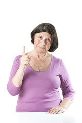 An elderly woman with a raised finger..
