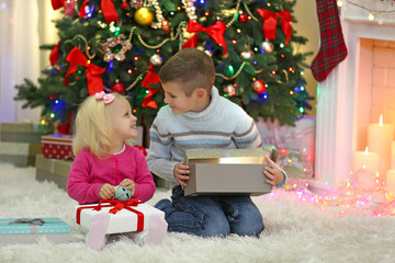 Obraz na płótnie Canvas Funny kids with gift boxes and Christmas tree on background