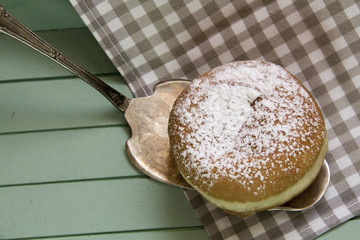 Sweet sugary donut on rustic wooden tray, top view of tasty bake