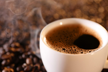 Cup of hot coffee on coffee beans background