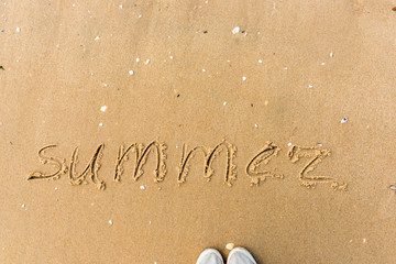 Summer written on the beach sand