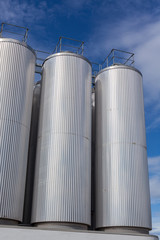 Giant industrial tanks on the bright blue sky
