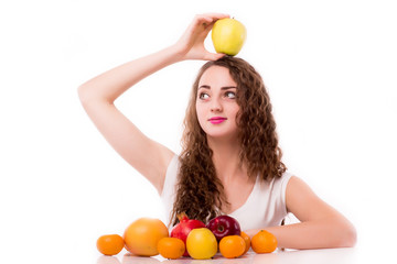 Glossy teen with apple on head / concept of attractive girl holding with fruits on white background