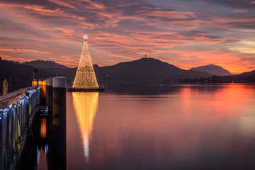Christmas tree on Lake Woerthersee during colorful sunset. Austria, Carinthia .