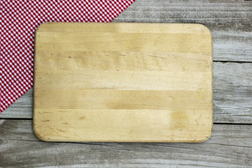 Blank cutting board with napkin border on wood background