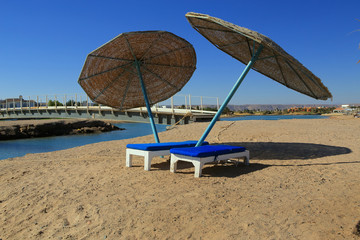 Two deck chairs with umbrellas on the beach. El Gouna. Egypt.