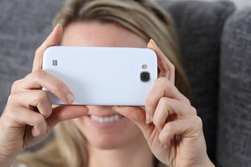 Frau mit Smartphone beim Fotografieren oder Chatten