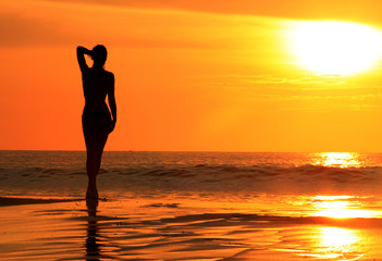Silhouette of a woman at sunset on the beach