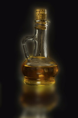 glass carafe with oil on a black background