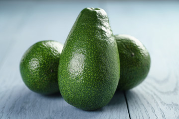 ripe green avocados on blue wood table