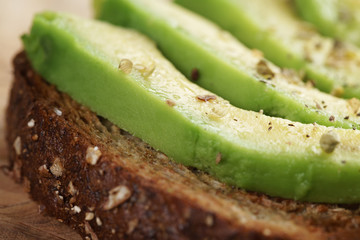 toasted rye bread with sliced avocado and herbs
