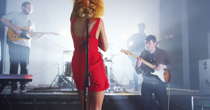  Beautiful charismatic female singer performing with band at live music event
