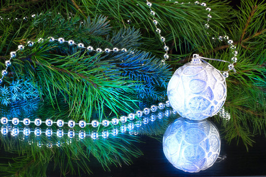 белый шар на фоне новогодней елки