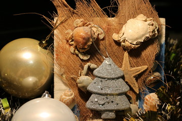 Новогодние елочные игрушки рядом с засушенной морской живностью