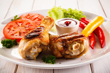 Grilled chicken legs with chips and vegetables 