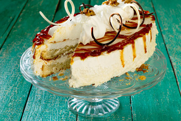 Cake with whipped cream decorated with chocolate candy nuts
